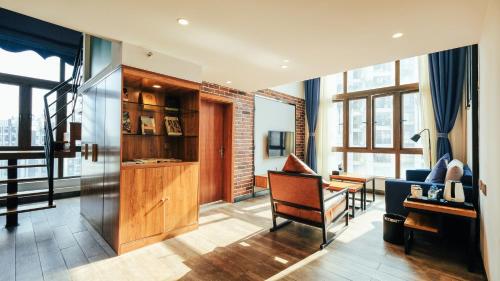 a living room with a chair and a desk at VIZ Culture & Arts Apartment in Nanning