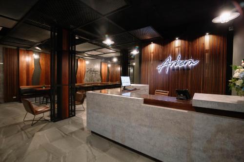 a lobby with a bar with an alesis sign on the wall at The Arbern Hotel x Bistro - SHA Extra Plus in Phuket Town