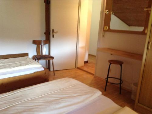a bedroom with a bed and two stools in it at Ferienhaus Bergland in Flachau