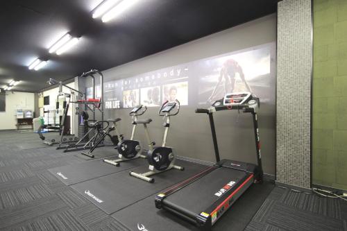 a gym with several treadmills and elliptical machines at Wat Hotel & Spa Hida Takayama in Takayama