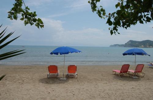 a group of chairs and umbrellas on a beach at Electra Apartments in Sidari