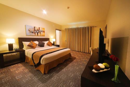 a hotel room with a bed and a television at Mount Sea Resort in Rosario