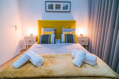 a bedroom with a large bed with two pillows on it at Lechartier Oporto apartments 3 in Porto