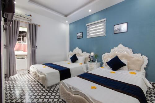 two beds in a room with blue walls at Hanoi Boutique House in Hanoi