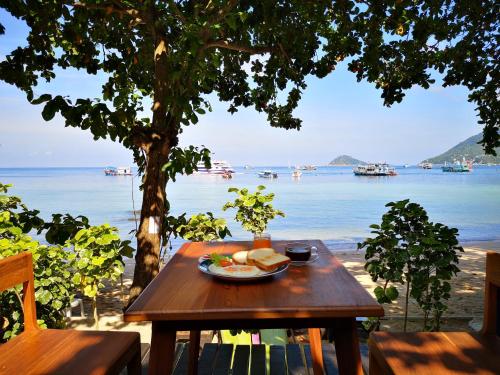 een picknicktafel met een bord eten op een strand bij Koh Tao Royal Resort in Ko Tao