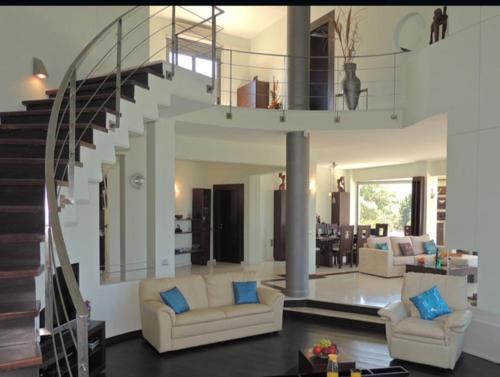 ゲラニ・シャニオンにあるProvarma hills luxury villa geraniのリビングルーム(ソファ2台、階段付)