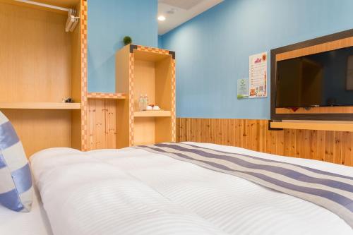 a bedroom with a bed and a flat screen tv at Yuan Su B&B in Yuchi