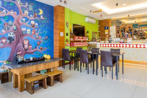 a restaurant with a dining room with a tree mural at Yuan Su B&B in Yuchi