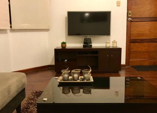 sala de estar con TV y mesa de centro en Departamento completo en San Borja, en Lima