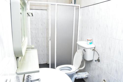 Łazienka z białą toaletą i umywalką w obiekcie Kandy View Hotel w mieście Kandy
