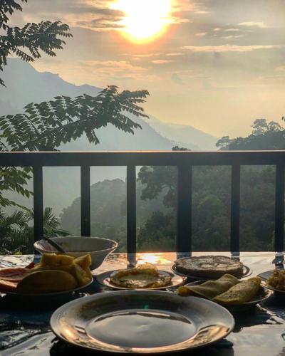 a table with plates of food on top of a mountain at adam's apple homestay in Ella