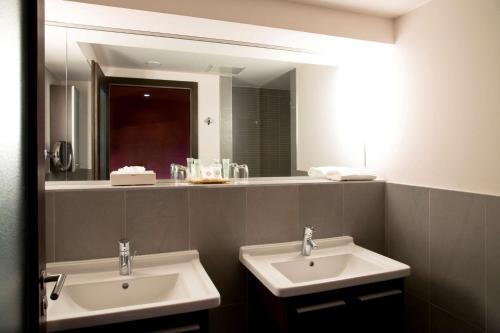 a bathroom with two sinks and a large mirror at Grand Hôtel Bristol in Colmar