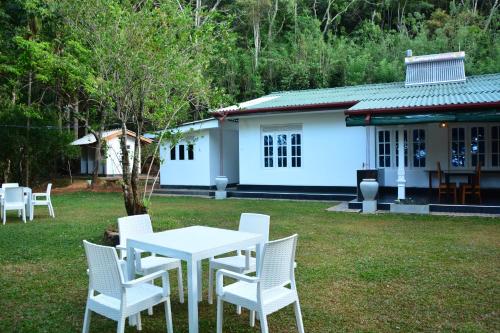 a white table and chairs in front of a house at Eagle Wings Holiday in Belihul Oya