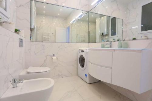 une salle de bain blanche avec une machine à laver à l'intérieur dans l'établissement Le Charme-35, à Nice