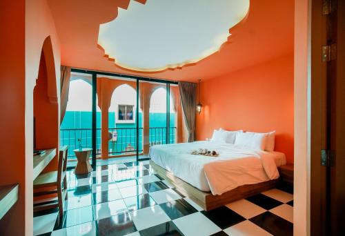 a bedroom with orange walls and a bed with a checkered floor at Khaleej Mass Hotel Patong in Patong Beach