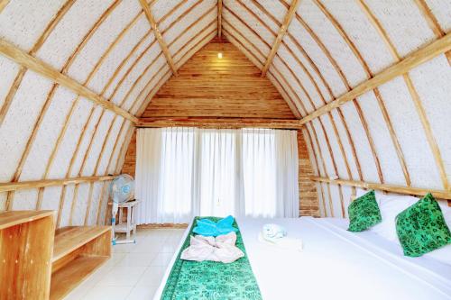 1 dormitorio con 1 cama en una habitación de madera en Gili Matiki en Gili Air