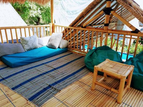 a gazebo with two pillows and a chair on a deck at Gili Matiki in Gili Air