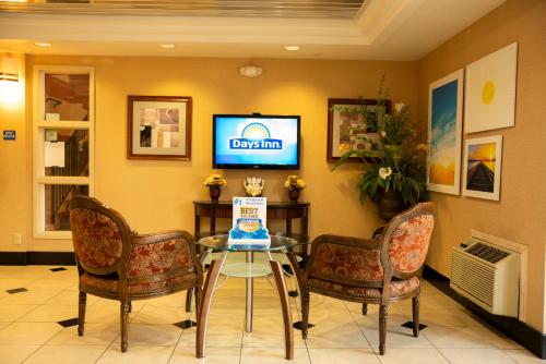 a dining room with a glass table and two chairs at Days Inn by Wyndham Concord in Concord