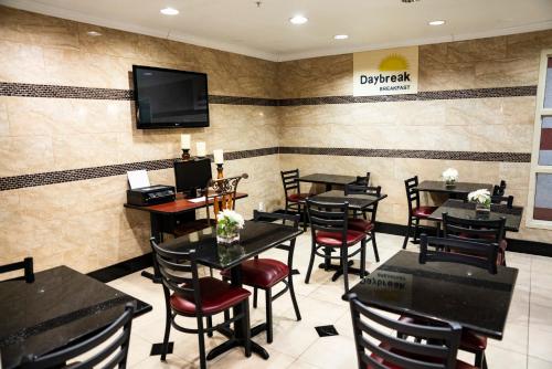 a restaurant with tables and chairs and a tv on the wall at Days Inn by Wyndham Concord in Concord