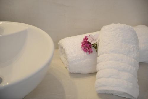 una pila de toallas en un mostrador junto a un fregadero en Villa Maria Apartments, en Akrotiri