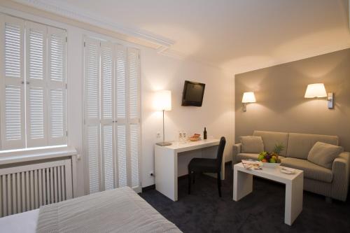 a hotel room with a bed and a desk and a couch at relexa hotel Schatten Stuttgart in Stuttgart