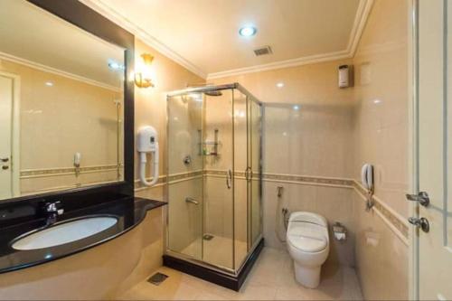 y baño con aseo, lavabo y ducha. en Regant Lake Palace Hotel, en Nīndakara