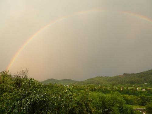 a rainbow in the sky over a city at Лелека in Delyatyn