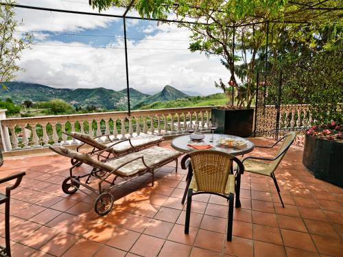 a patio with a table and chairs and a view at Hotel Scapolatiello in Cava deʼ Tirreni
