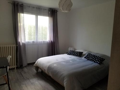 a bedroom with a bed with pillows and a window at BdB nid douillet au rdc rando ressourçante in Bagnères-de-Bigorre