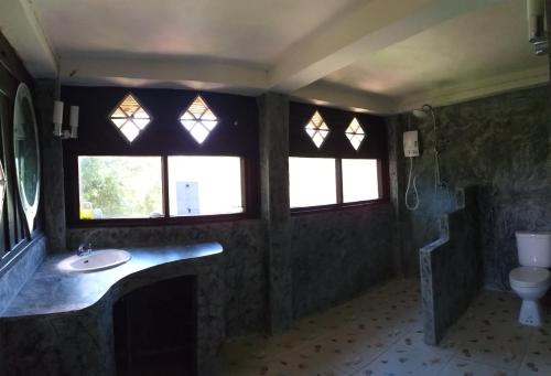 a bathroom with a sink and two windows and a toilet at Koh Tao Royal Resort in Ko Tao