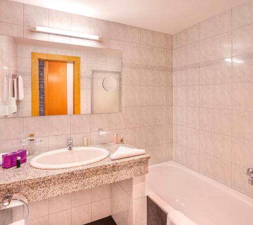 a bathroom with a sink and a tub and a mirror at Ad Laca in See