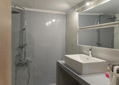 a white bathroom with a sink and a shower at Penelope's Luxury Apartment in Athens