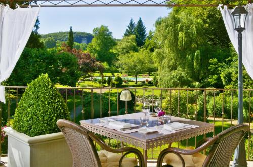 a table and chairs on a patio with a view at Les Glycines - Hôtel & Spa - Teritoria in Les Eyzies-de-Tayac