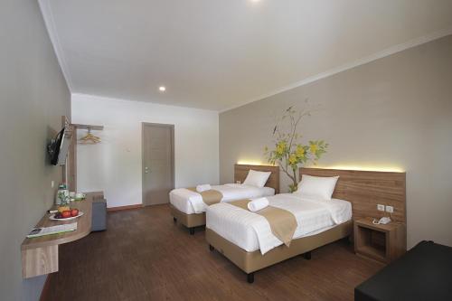 a bedroom with two beds and a television in it at Three Eight Front One Boutique Batu Malang in Batu