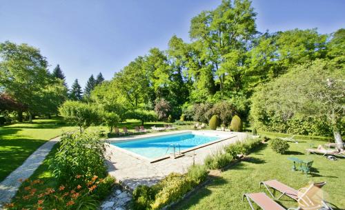 una imagen de una piscina en un jardín en Les Glycines - Hôtel & Spa - Teritoria, en Les Eyzies-de-Tayac