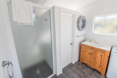 a bathroom with a shower and a sink at Miramar Cottage in Denmark