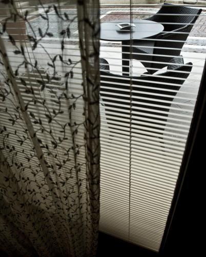 a window with blinds on it with a table in front of it at Leventis Art Suites in Panayítsa