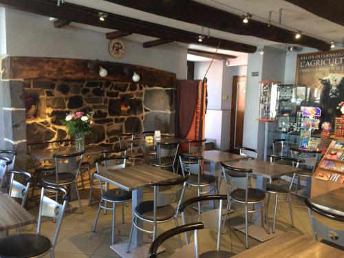 un restaurant avec des tables et des chaises et un mur en pierre dans l'établissement GITE DU FORAIL, à Laguiole