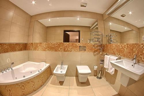 a bathroom with two sinks and a tub and a toilet at Hotel & Browar Słociak in Opole