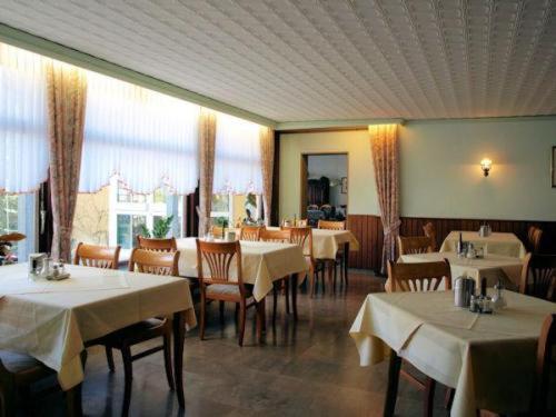 Hotel-Pension Ursula في باد ساخسا: غرفة طعام مع طاولات وكراسي مع قماش الطاولة البيضاء