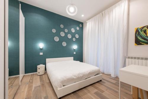 - une chambre avec un lit blanc et un mur vert dans l'établissement Rainbow Suite, à Cassino
