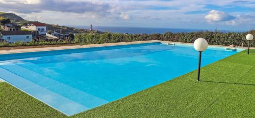 a blue swimming pool with a view of the ocean at Casa de Campo, Algarvia in Algarvia
