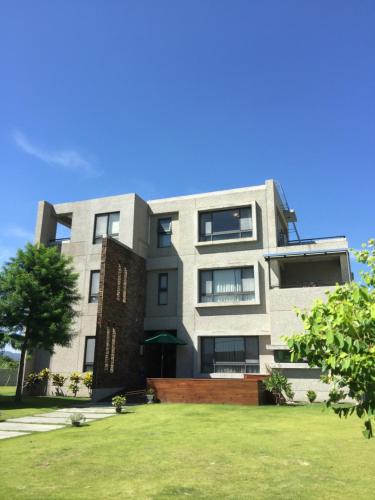 an apartment building with a lawn in front of it at Duck's Home B&B in Jian