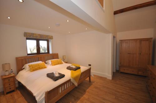 Un dormitorio con una cama grande y una ventana en Moulton-Barrett Barn en Bideford