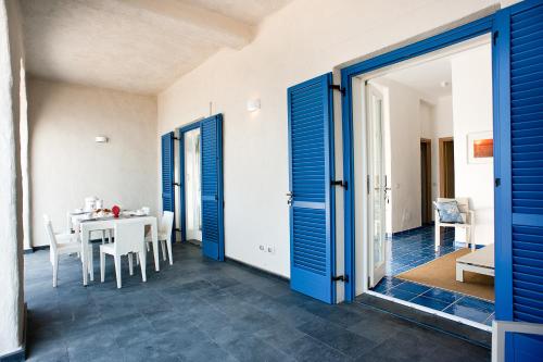 a dining room with blue doors and a table at NerOssidiana in Acquacalda