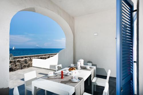 a table and chairs with a view of the ocean at NerOssidiana in Acquacalda