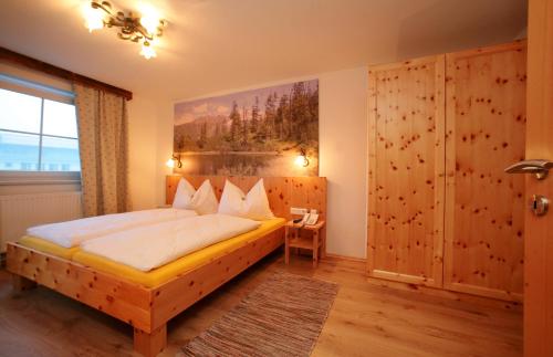 ein Schlafzimmer mit einem Bett und einem Wandgemälde in der Unterkunft Aparthotel Waidmannsheil in Kaprun