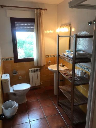 a bathroom with a toilet and a sink at HOSPEDAJE CASA MARIANO in Segovia