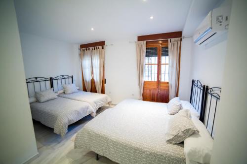 a bedroom with two beds and a window at Casa Grande En Centro Historico in Córdoba