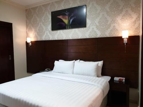a bedroom with a large white bed in a hotel room at Mirage Al Salam Hotel in Medina